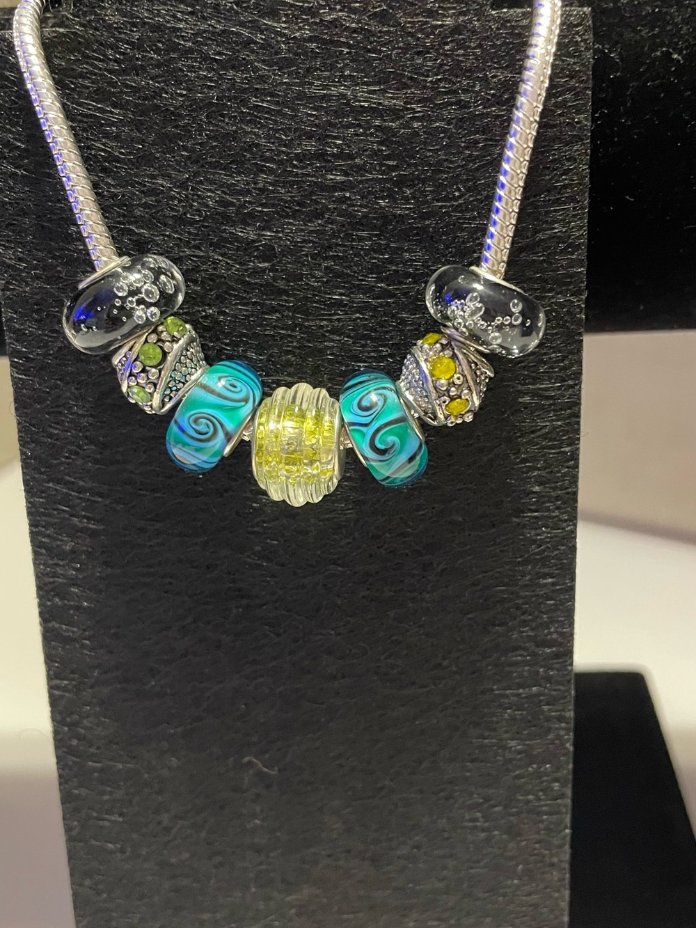8” Sterling Silver Rope bracelet with Blue, black & yellow beads and charms.